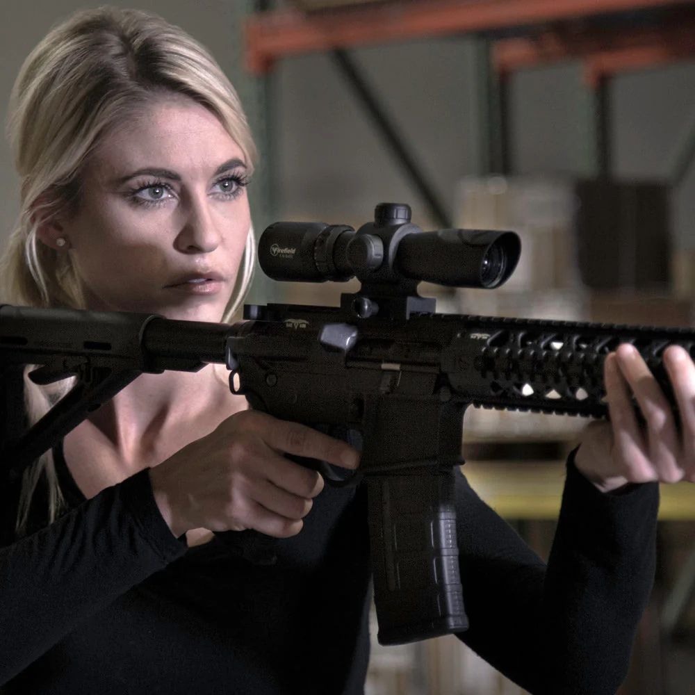 Ragazza con Firefield ottica montata su un fucile softair