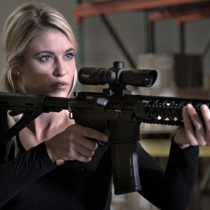 Ragazza con Firefield ottica montata su un fucile softair